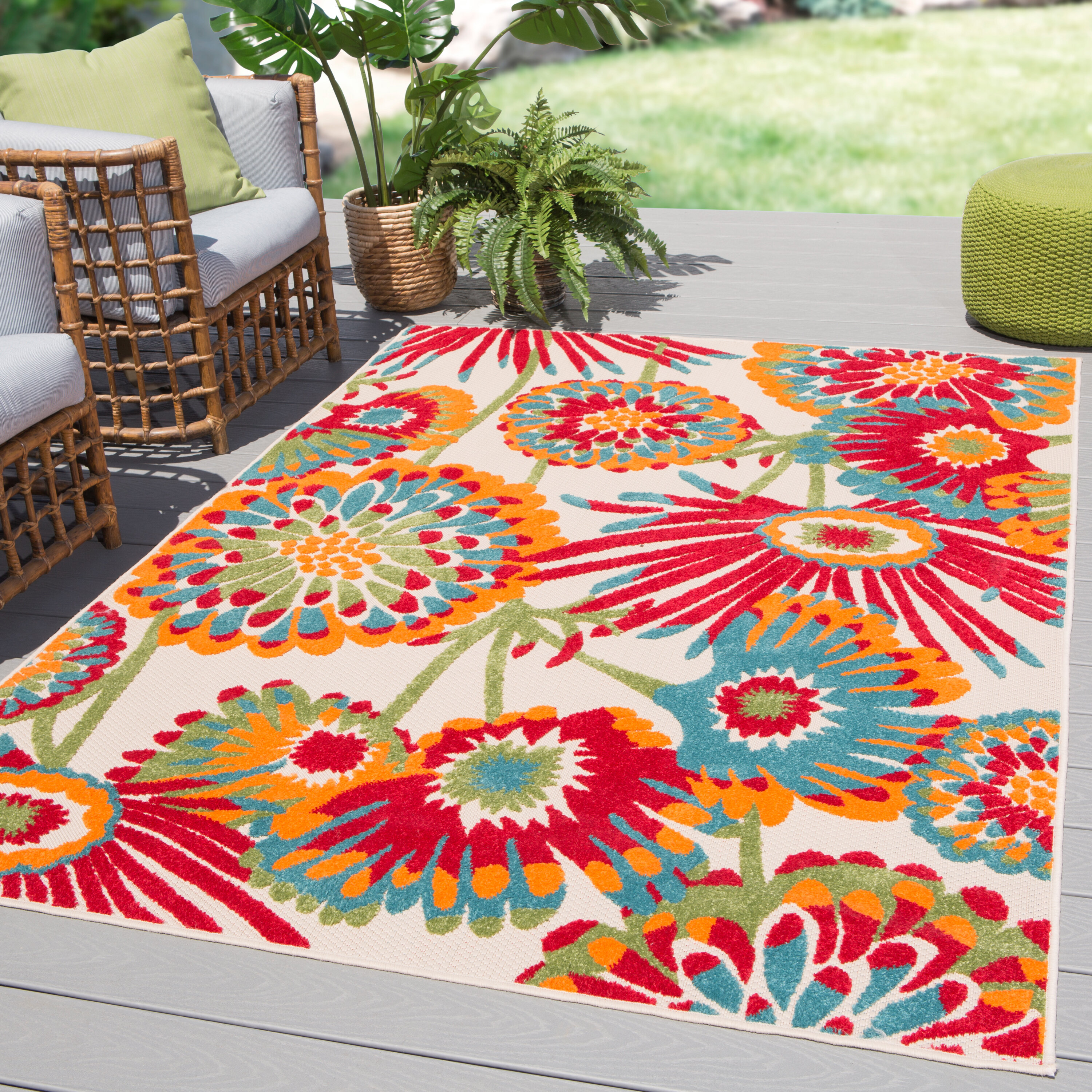 ReStylist Catenya McHenry creates an outdoor space by adding a tabb-floral-redblue-indooroutdoor-area-rug from Wayfair